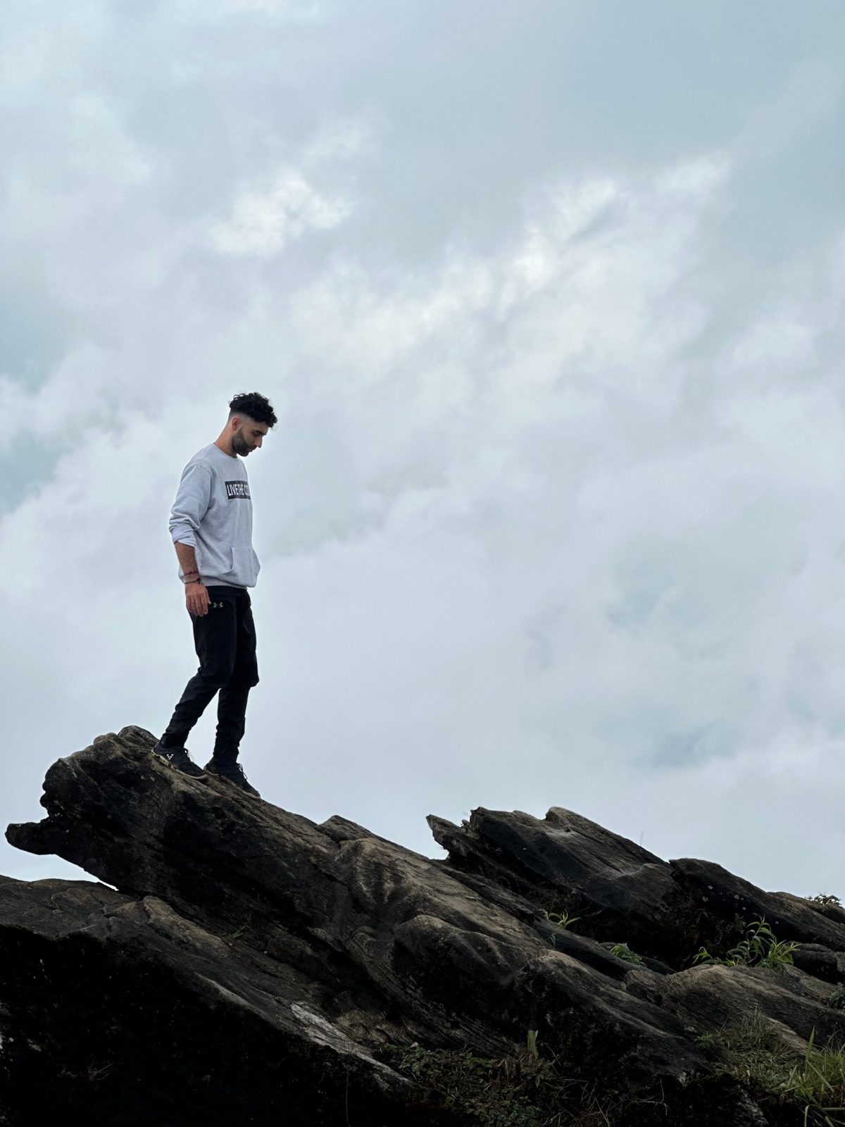 Cava standing on a rock above the clouds, looking down